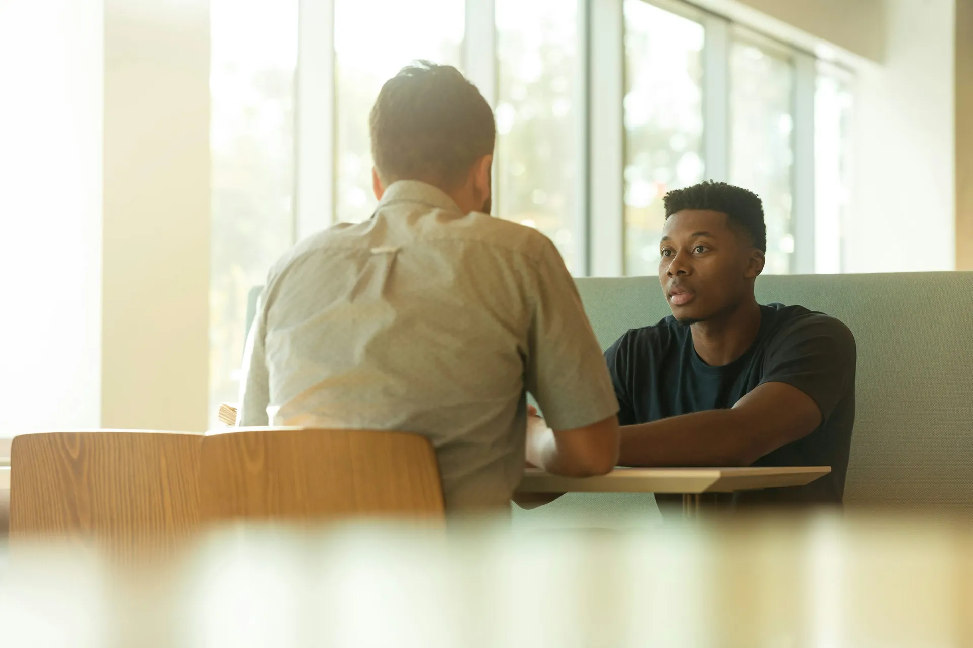 Two adults talking together in a warm, supportive conversation